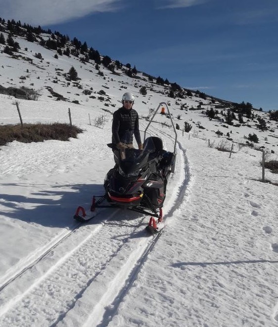 Technicien près d'une motoneige nous regardant