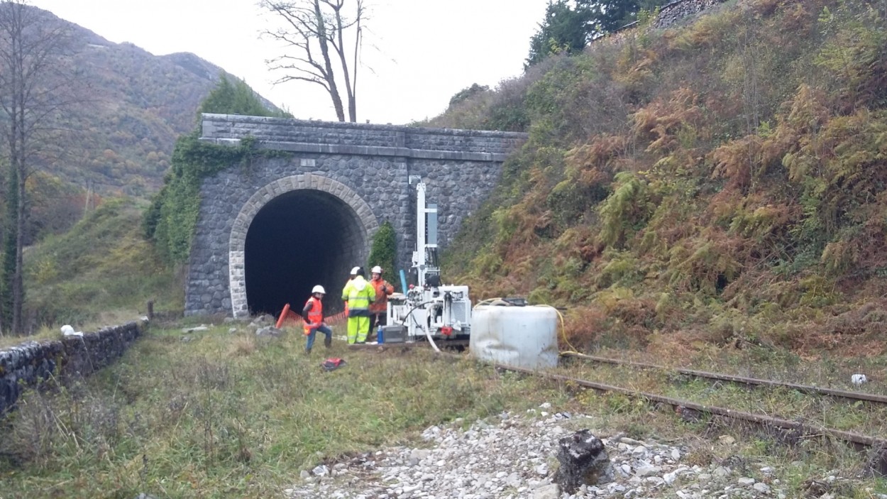 Hommes sur chantier ligne ferroviaire devant entrée de tunnel