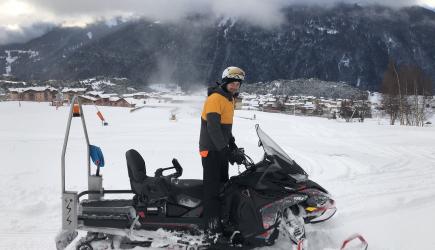 Technicien debout sur motoneige