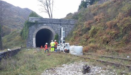 Hommes sur chantier ligne ferroviaire devant entrée de tunnel